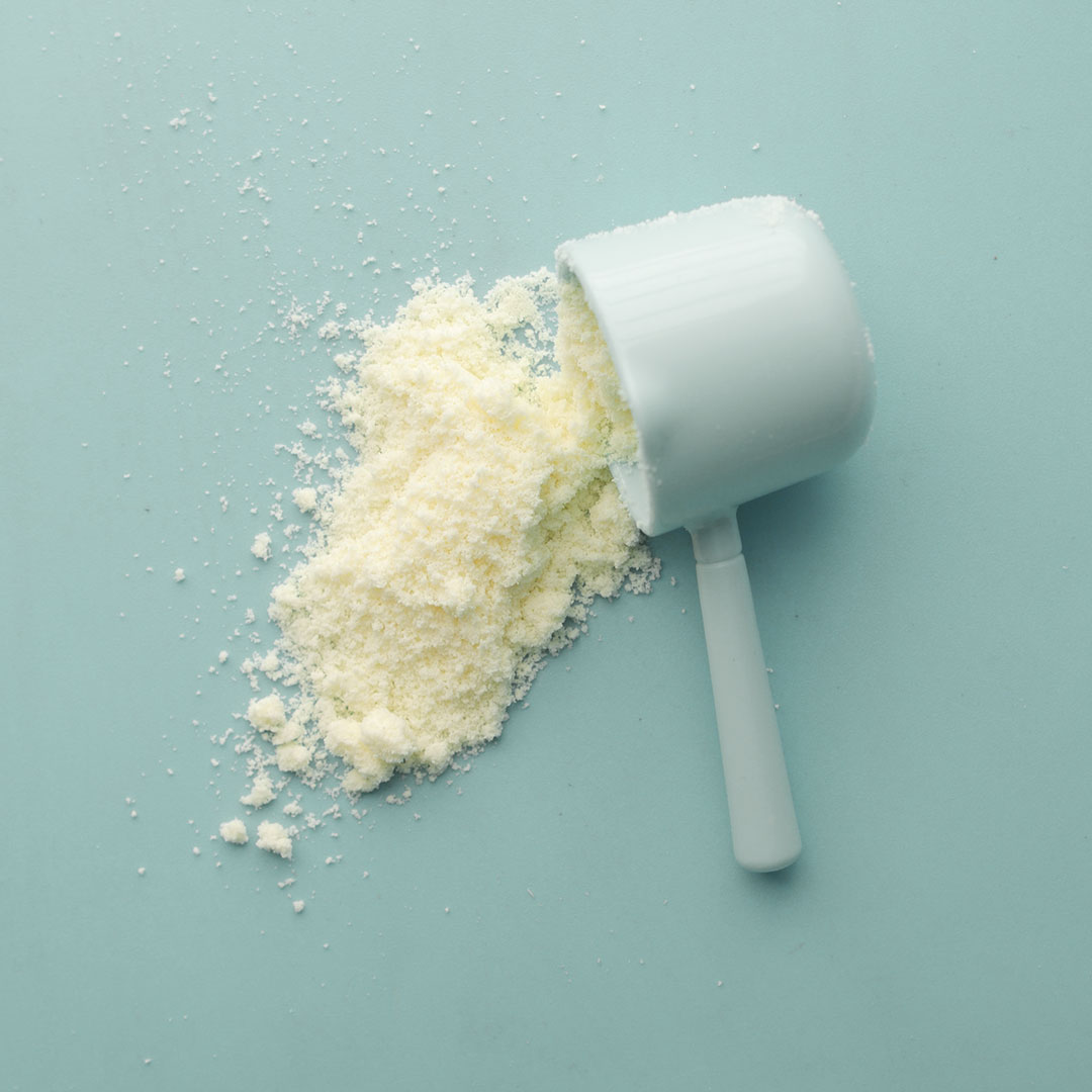 a white powder and scoop on a blue background