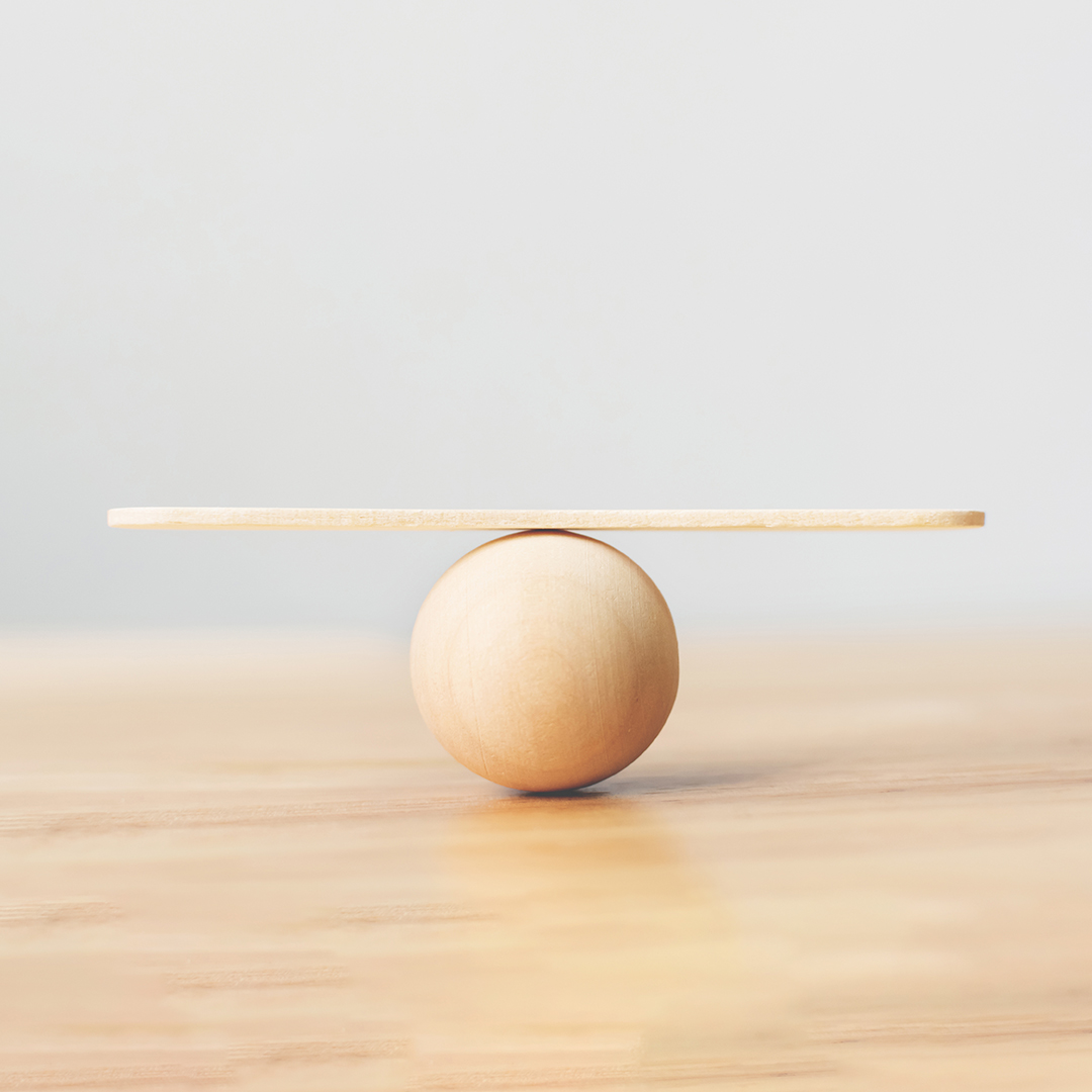 a wooden circle with a wooden plank on top balancing