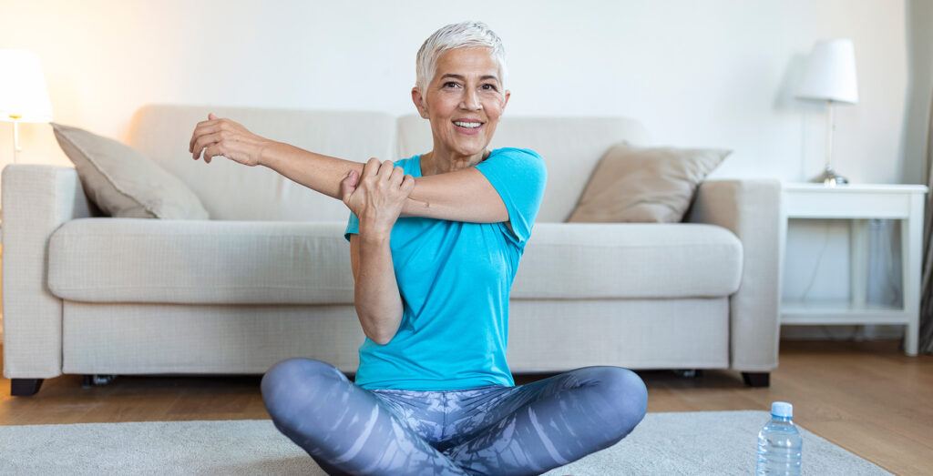 older fit woman in her living room doing yoga